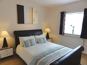 The Mews Cottage - Leather king sized bed with quality fitted bedroom furniture with ample storage.